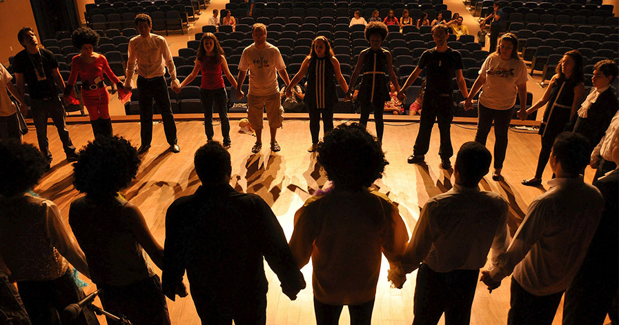People standing in circle on a stage