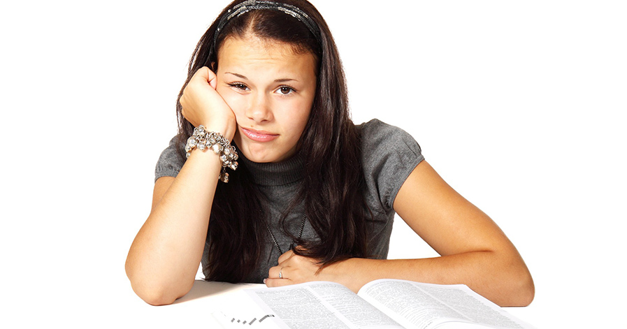Girl looking bored with open textbook in front of her