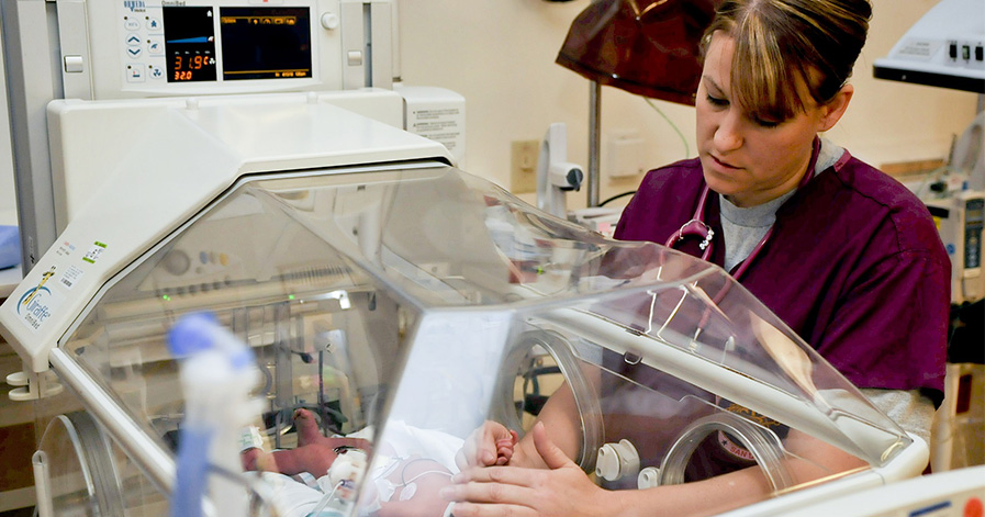 Nurse looking after a baby in an incubator